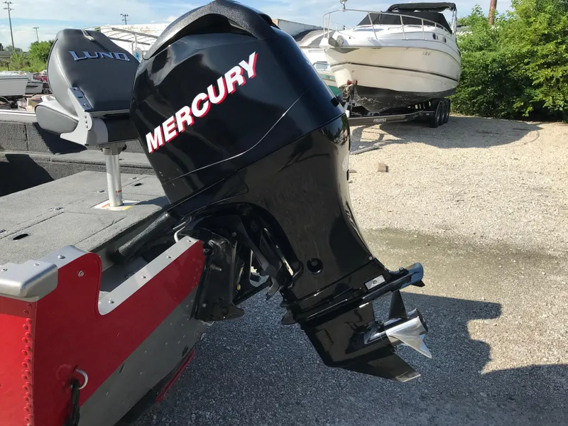 Slide: The Image of 2011 Lund 1775 Impact boat with Mercury outboard motor, parked on gravel. - 7