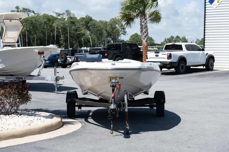 Slide: The Image of 2017 Scarab 165 G boat on trailer in parking lot with palm tree and vehicles. - 3