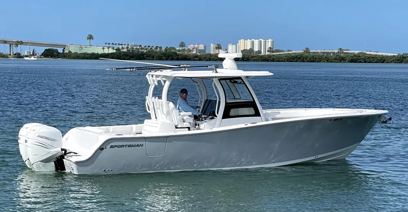 Slide: The Image of 2021 Sportsman Open 322 Center Console boat on calm water, cityscape in background. - 38