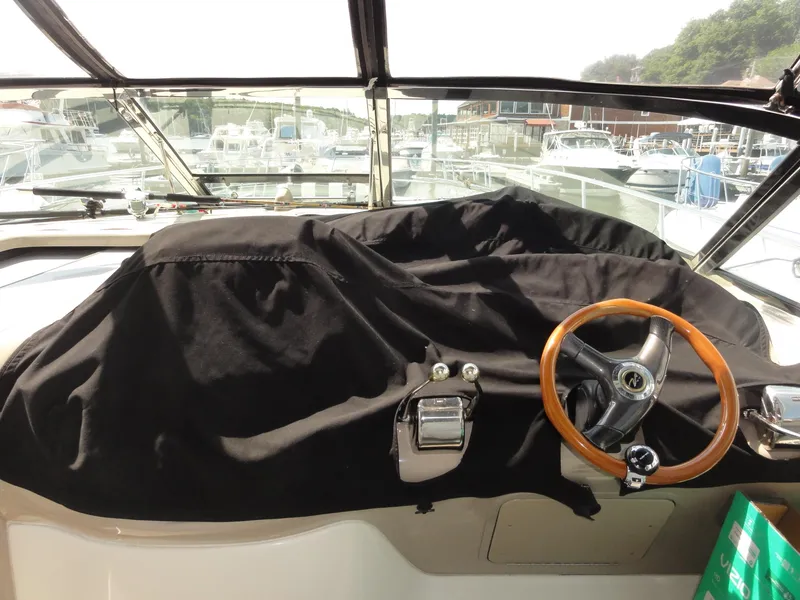 Slide: The Image of Helm of 2003 Sea Ray 380 Sundancer with covered dashboard and wooden steering wheel. - 10