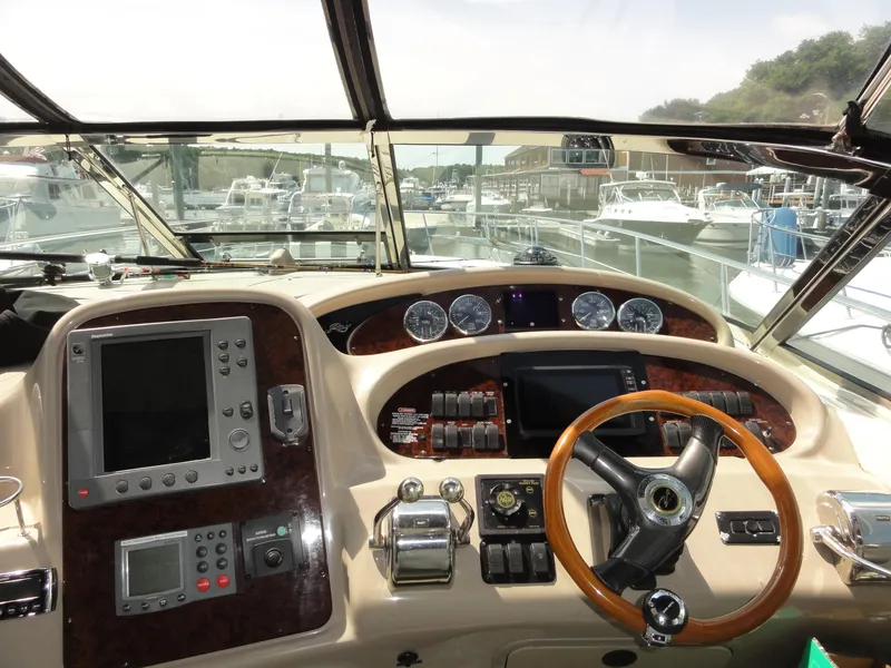 Slide: The Image of 2003 Sea Ray 380 Sundancer helm with navigation instruments and steering wheel at marina. - 12