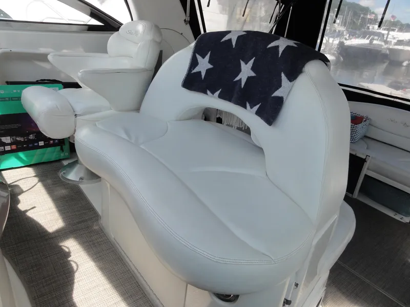 Slide: The Image of Interior of 2003 Sea Ray 380 Sundancer with white seating and star-patterned blanket. - 18