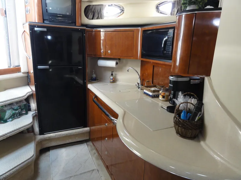 Slide: The Image of 2003 Sea Ray 380 Sundancer yacht kitchen with modern appliances and wooden cabinetry. - 25