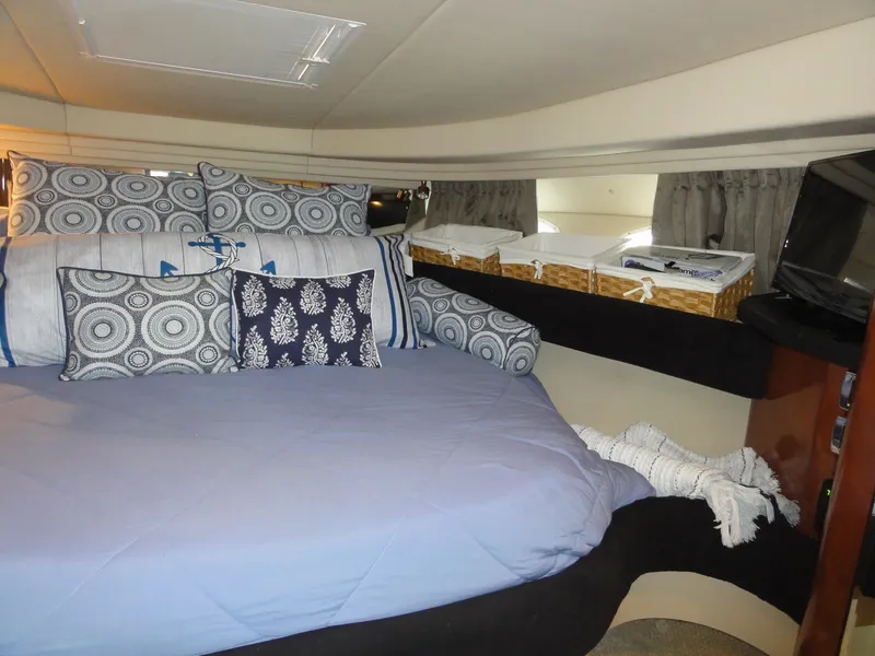 Slide: The Image of Cozy cabin interior of 2003 Sea Ray 380 Sundancer with decorative pillows and storage baskets. - 27