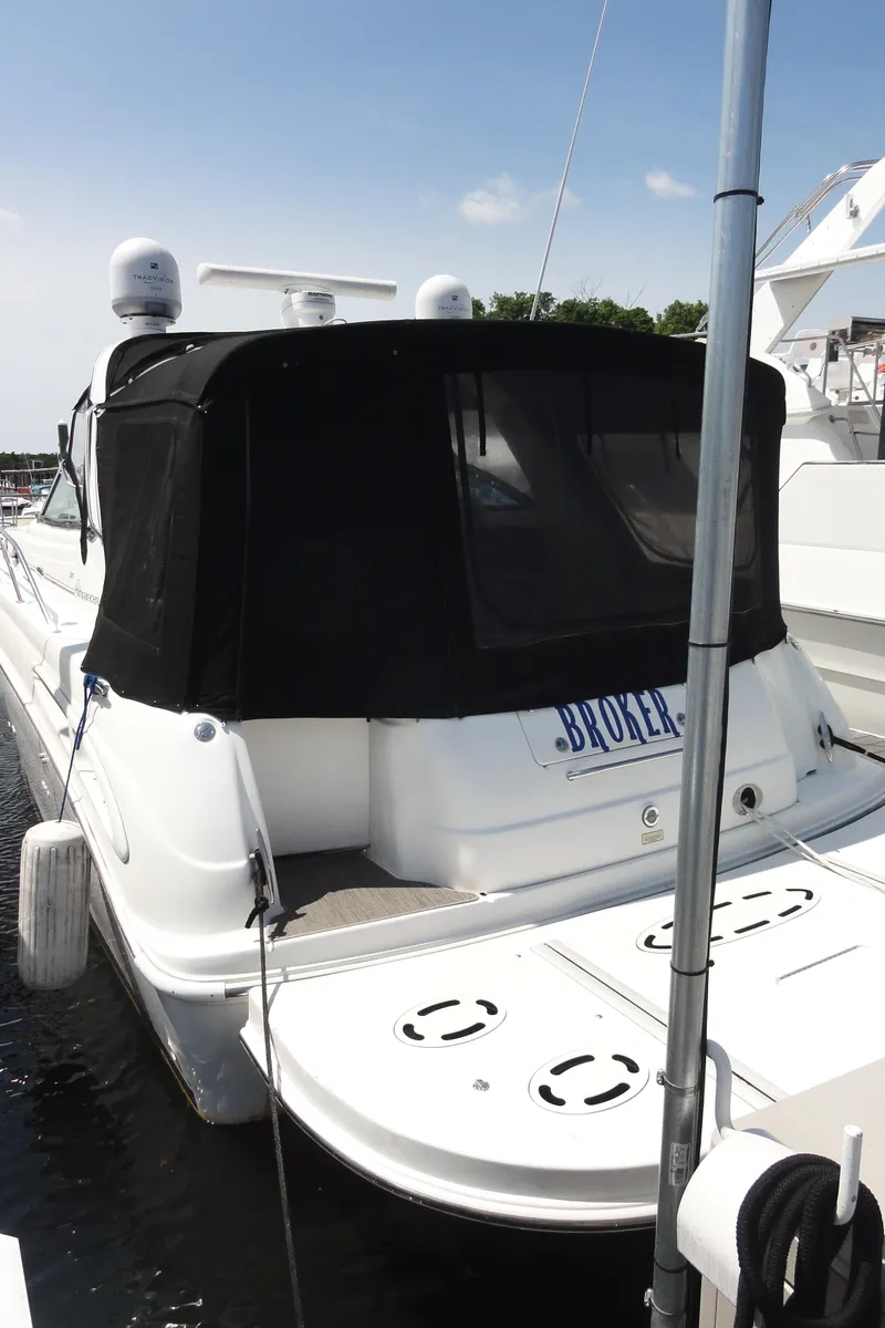 Slide: The Image of 2003 Sea Ray 380 Sundancer yacht docked, featuring a black canopy and white hull. - 6