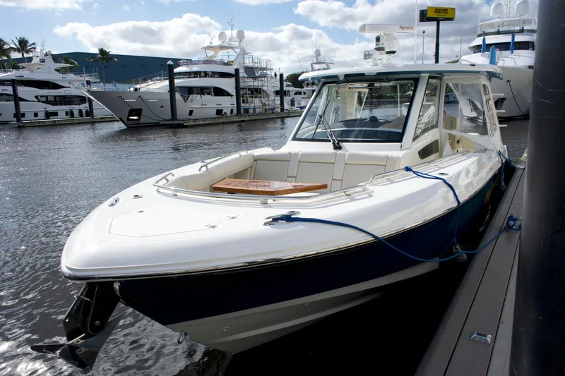 Slide: The Image of 2020 Boston Whaler 350 Realm boat docked at marina, surrounded by yachts. - 20