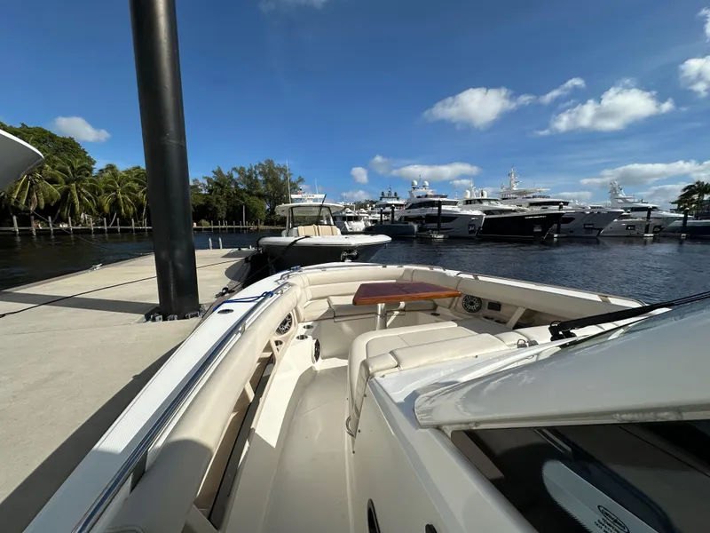 Slide: The Image of 2020 Boston Whaler 350 Realm docked at marina with yachts in background. - 21