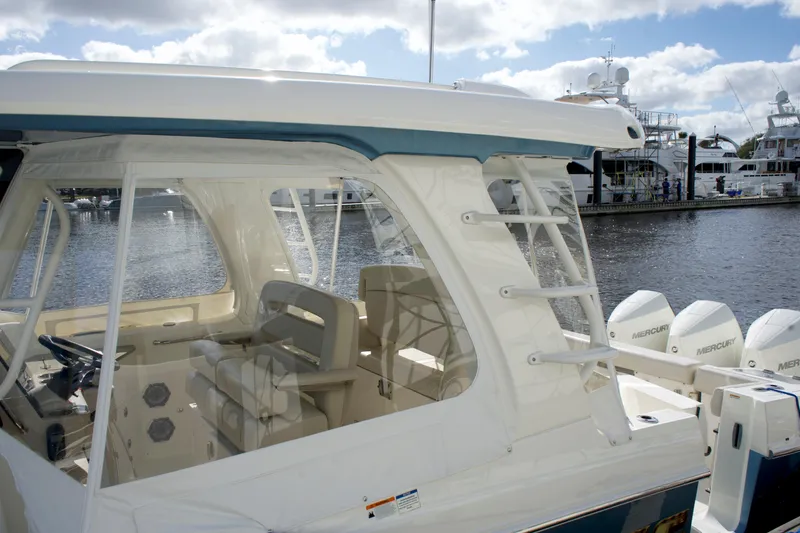 Slide: The Image of 2020 Boston Whaler 350 Realm boat docked, showcasing interior seating and exterior design. - 24