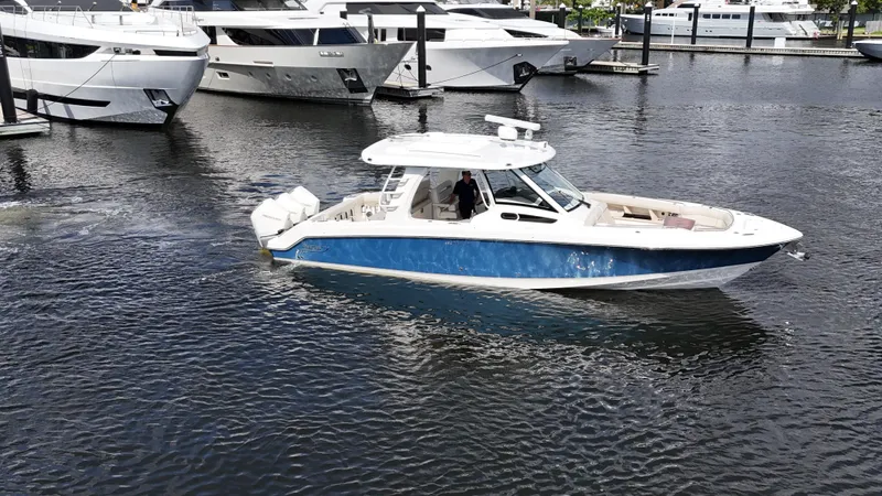 Slide: The Image of 2020 Boston Whaler 350 Realm boat cruising in marina with yachts in background. - 3
