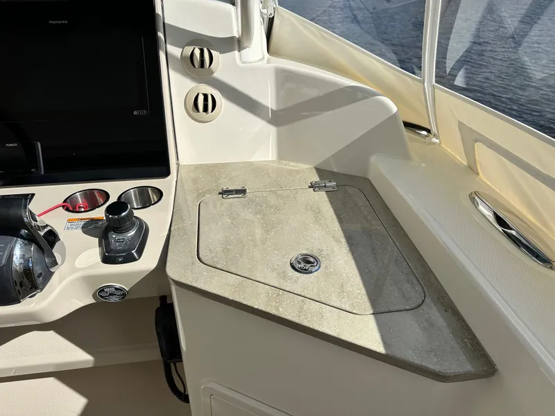 Slide: The Image of 2020 Boston Whaler 350 Realm helm station with control panel and storage compartment. - 34
