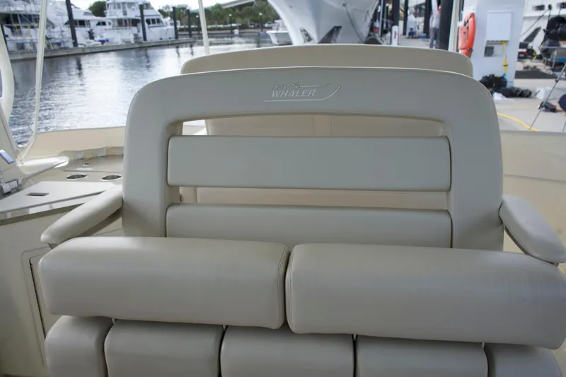 Slide: The Image of 2020 Boston Whaler 350 Realm boat seat, beige leather, docked marina background. - 37