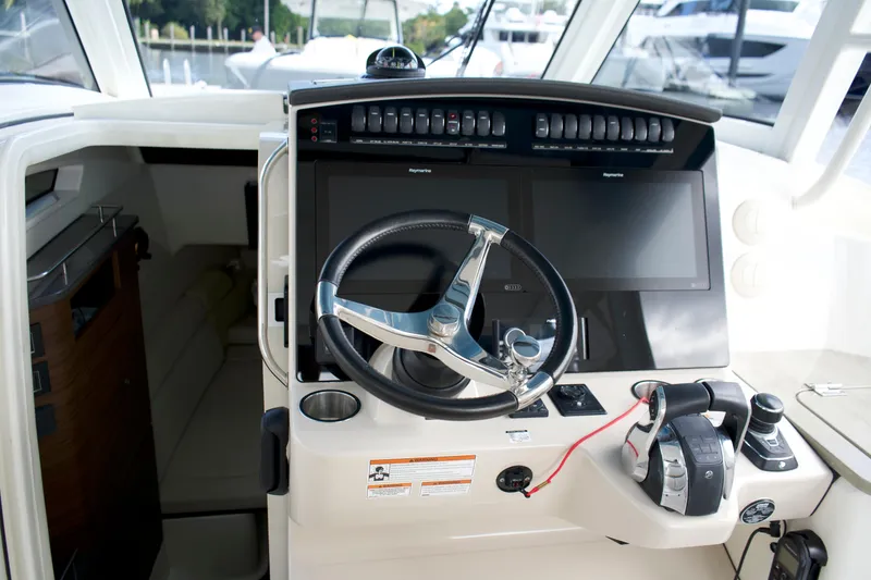 Slide: The Image of 2020 Boston Whaler 350 Realm helm with dual screens and modern controls. - 41