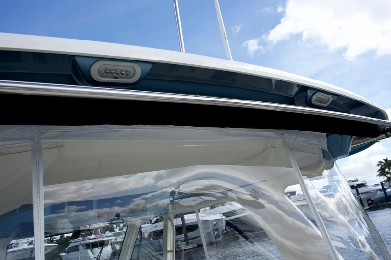 Slide: The Image of 2020 Boston Whaler 350 Realm boat with clear canopy and sleek design against a marina backdrop. - 48