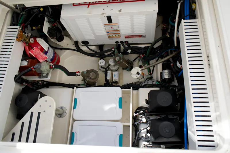 Slide: The Image of Engine compartment of a 2020 Boston Whaler 350 Realm, showcasing mechanical components and storage. - 57