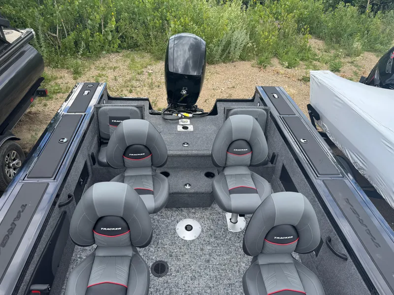 Slide: The Image of 2026 Tracker Targa V-18 Combo boat interior with four gray seats and motor. - 11