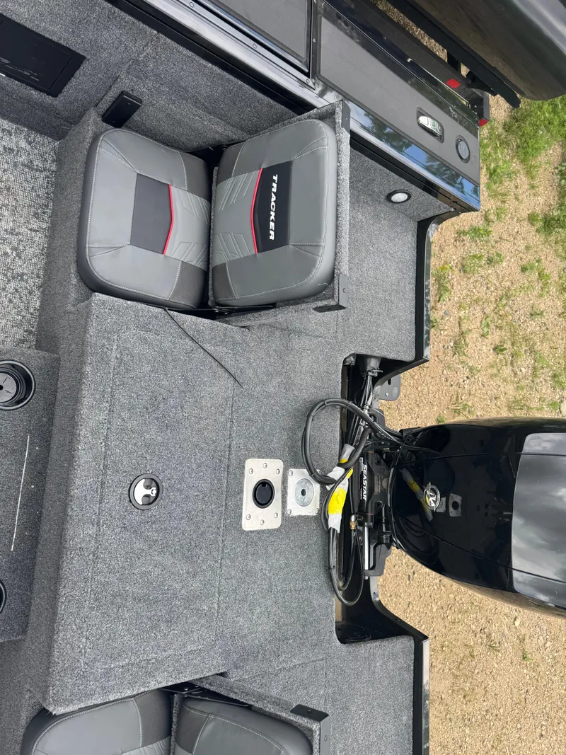 Slide: The Image of 2026 Tracker Targa V-18 Combo boat interior with seating and motor, featuring gray upholstery. - 15