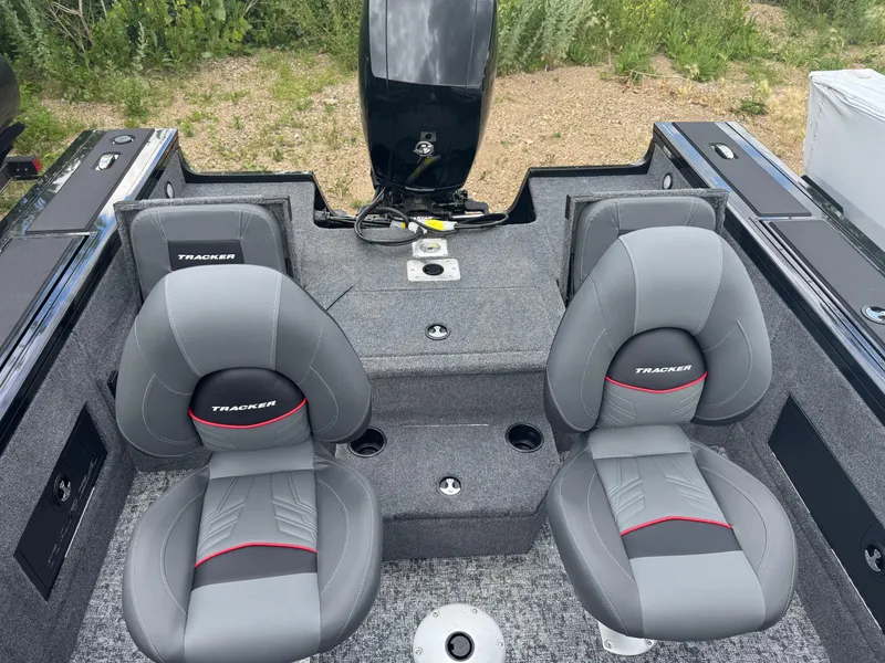 Slide: The Image of 2026 Tracker Targa V-18 Combo boat interior with two gray seats and motor. - 6