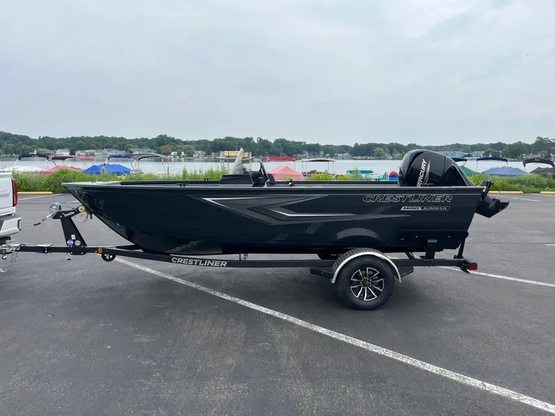 The Image of 2025 Crestliner 1650 Kodiak boat on trailer, parked near a scenic lake. - 1