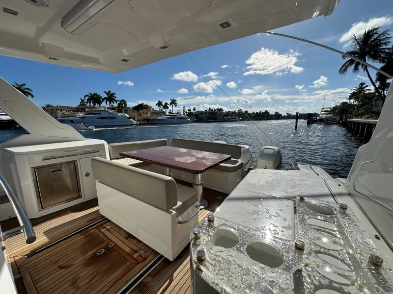 Slide: The Image of 2018 Azimut Verve 40 yacht deck with seating, table, and waterfront view. - 20