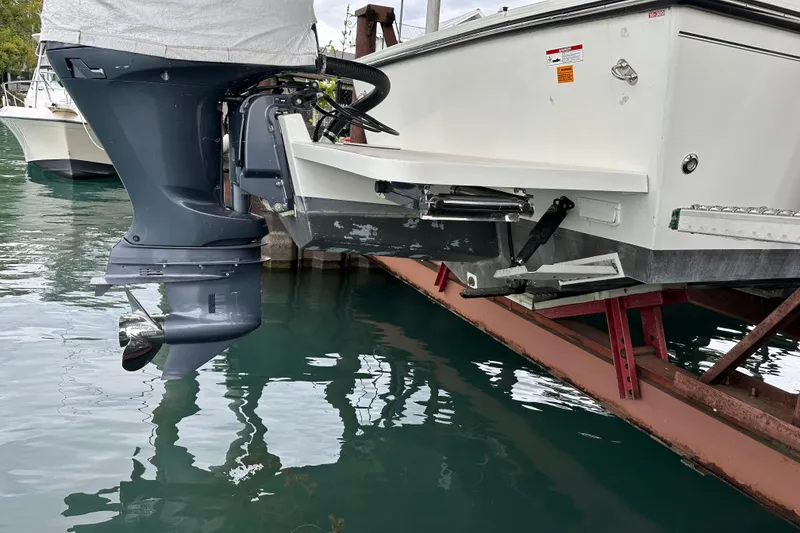 Slide: The Image of 2016 Parker 2320 SL Sport Cabin boat with outboard motor on a dock. - 10