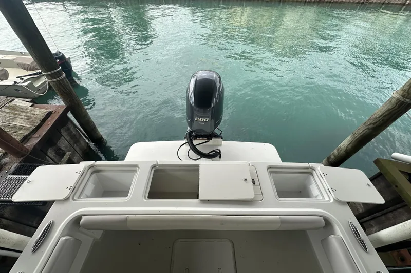 Slide: The Image of 2016 Parker 2320 SL Sport Cabin boat with outboard motor, docked on calm water. - 11