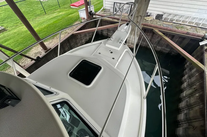 Slide: The Image of 2016 Parker 2320 SL Sport Cabin boat docked in a sheltered area. - 13