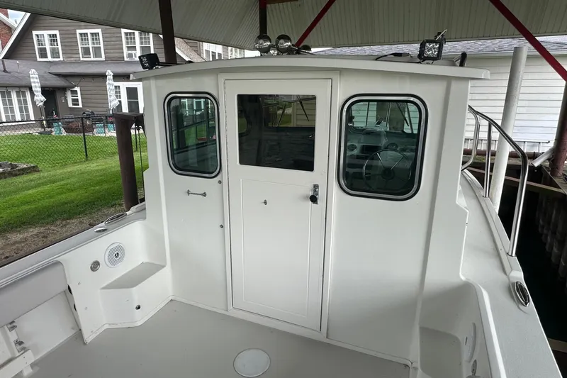 Slide: The Image of 2016 Parker 2320 SL Sport Cabin boat under a covered dock. - 16