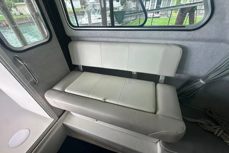 Slide: The Image of Interior seating of a 2016 Parker 2320 SL Sport Cabin boat, featuring white cushioned bench. - 19