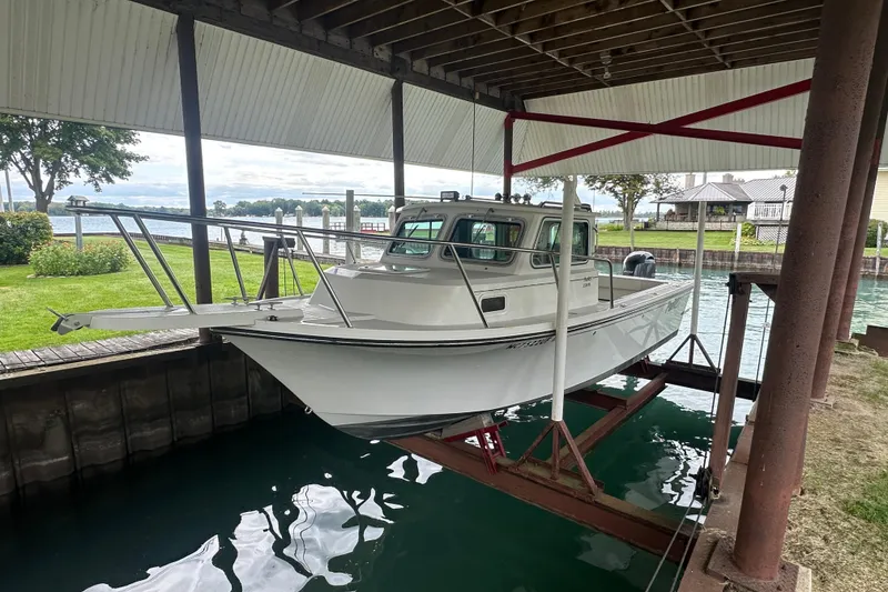 Slide: The Image of 2016 Parker 2320 SL Sport Cabin boat on lift under covered dock. - 3