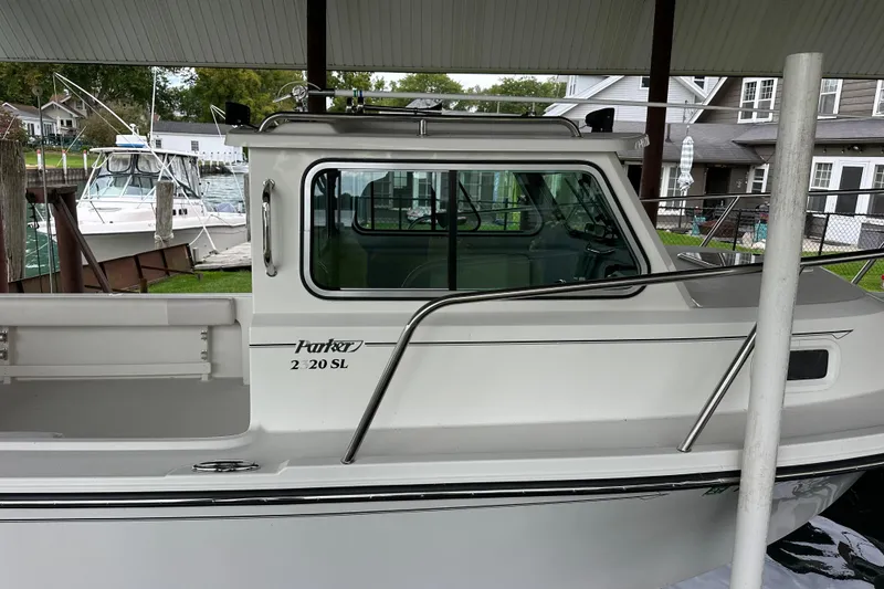 Slide: The Image of 2016 Parker 2320 SL Sport Cabin boat docked under a covered area. - 4