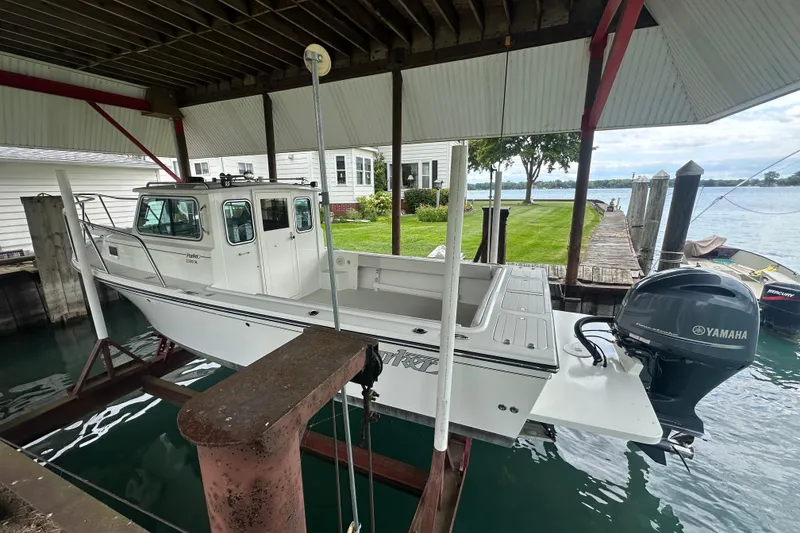 Slide: The Image of 2016 Parker 2320 SL Sport Cabin boat on lift, dockside with Yamaha outboard motor. - 5