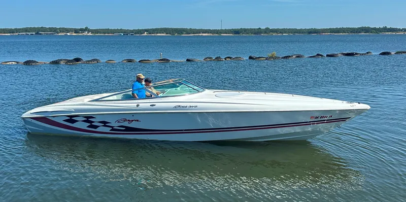 Slide: The Image of 2000 Baja 342 speedboat on calm lake with two passengers, clear sky, and distant shoreline. - 10