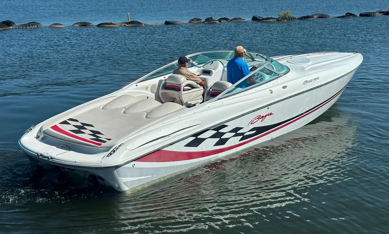 Slide: The Image of 2000 Baja 342 speedboat cruising on a calm lake with two passengers. - 13