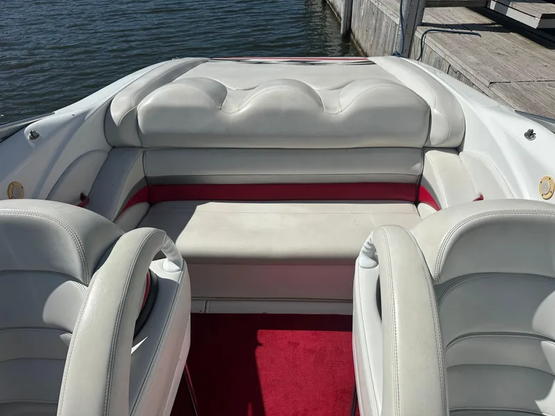 Slide: The Image of Interior of a 2000 Baja 342 boat with white and red seating by the water. - 17