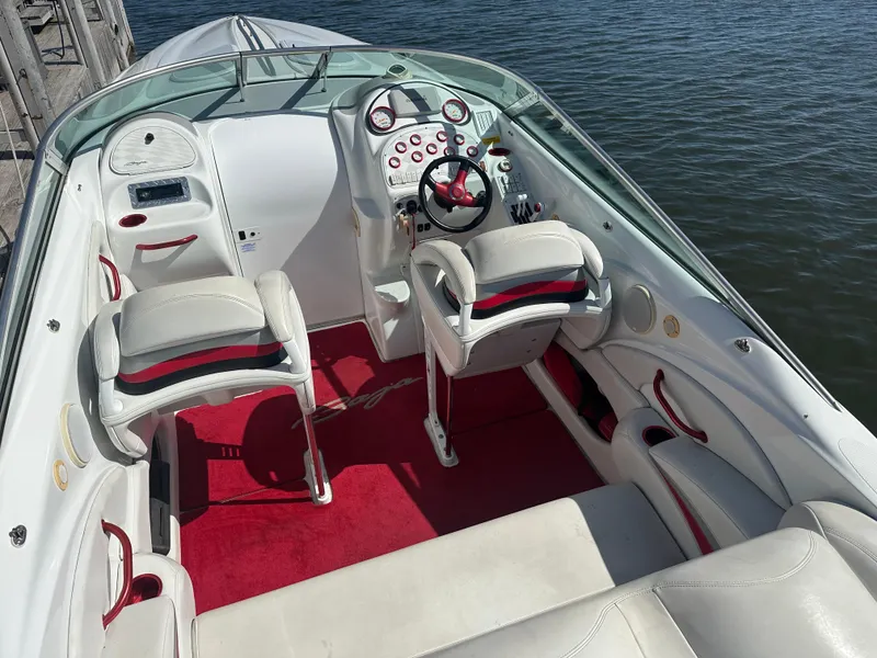 Slide: The Image of Interior of a 2000 Baja 342 boat with white and red seating, docked by water. - 19
