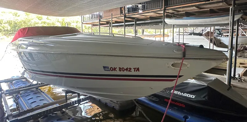 Slide: The Image of 2000 Baja 342 speedboat docked under a canopy, featuring sleek design and red accents. - 23