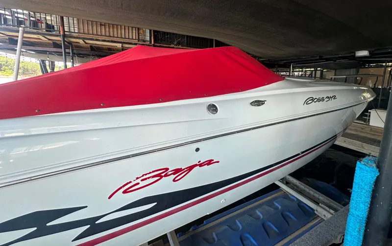 Slide: The Image of 2000 Baja 342 boat with red cover, docked in a marina. - 24