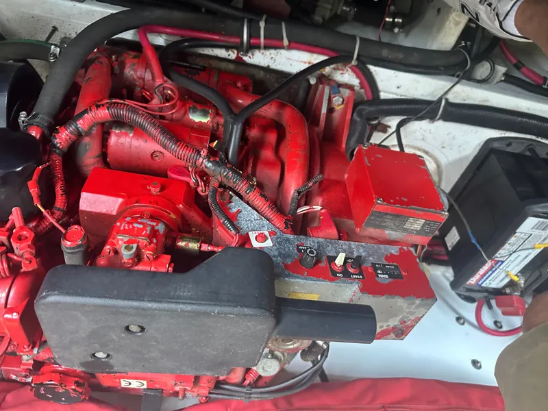 Slide: The Image of Engine compartment of a 2000 Baja 342 boat, featuring red components and wiring. - 27