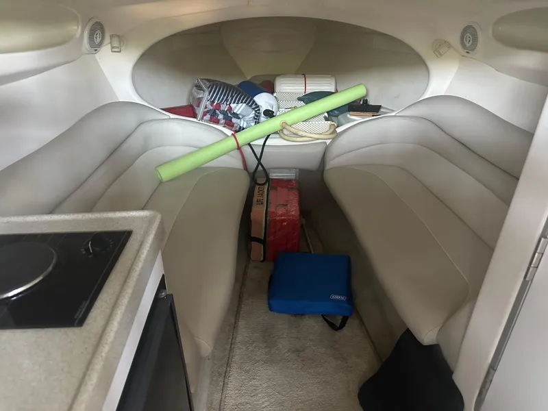 Slide: The Image of Interior of a 2000 Baja 342 boat with seating and stored items. - 28