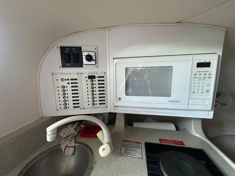 Slide: The Image of Boat kitchen with microwave, sink, and control panel in a 2000 Baja 342 model. - 30