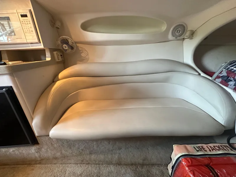 Slide: The Image of Interior of a 2000 Baja 342 boat with white leather seating and compact kitchen amenities. - 33