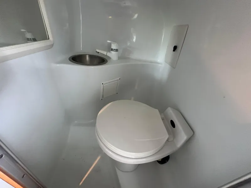 Slide: The Image of Compact bathroom in a 2000 Baja 342 boat with toilet and sink. - 37