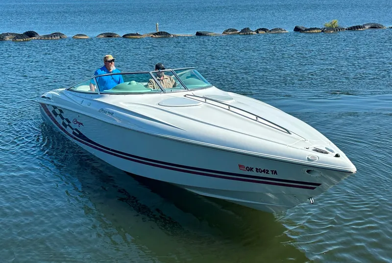 Slide: The Image of 2000 Baja 342 boat cruising on a calm lake with two passengers. - 6