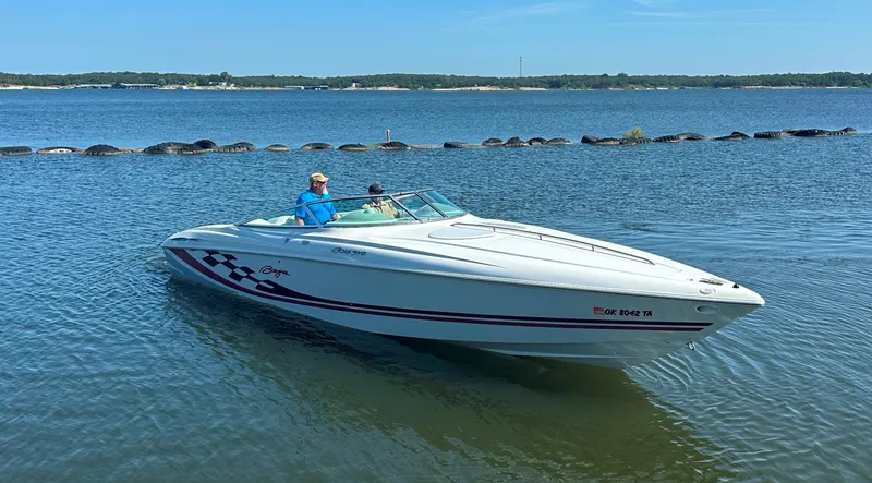 Slide: The Image of 2000 Baja 342 boat cruising on a calm lake under a clear blue sky. - 7