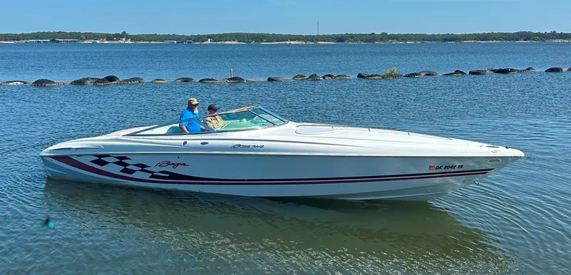 Slide: The Image of 2000 Baja 342 speedboat on a calm lake with two people onboard. - 9