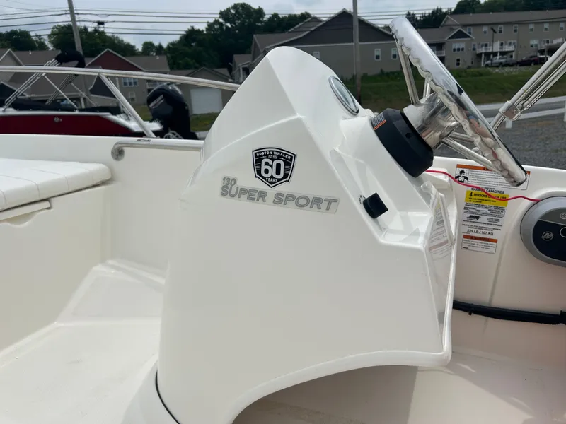 Slide: The Image of 2018 Boston Whaler 130 Super Sport boat interior with steering wheel and logo. - 12