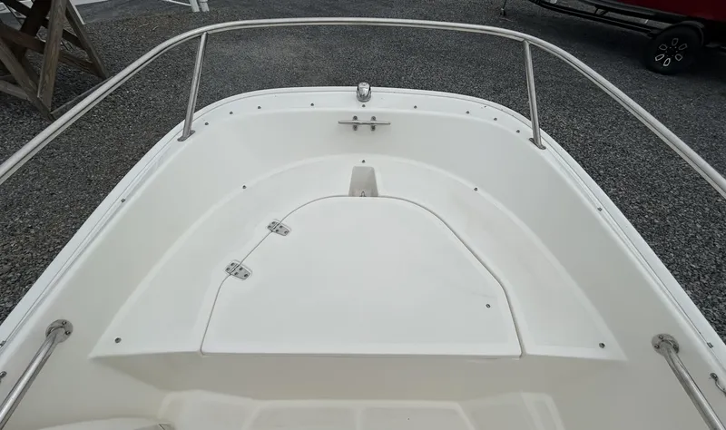 Slide: The Image of 2018 Boston Whaler 130 Super Sport boat interior, featuring a clean, white deck and stainless steel railings. - 13