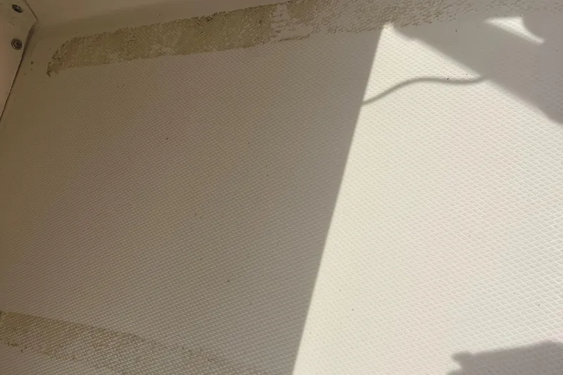 Slide: The Image of Interior of a 2018 Boston Whaler 130 Super Sport boat, showing textured flooring. - 15