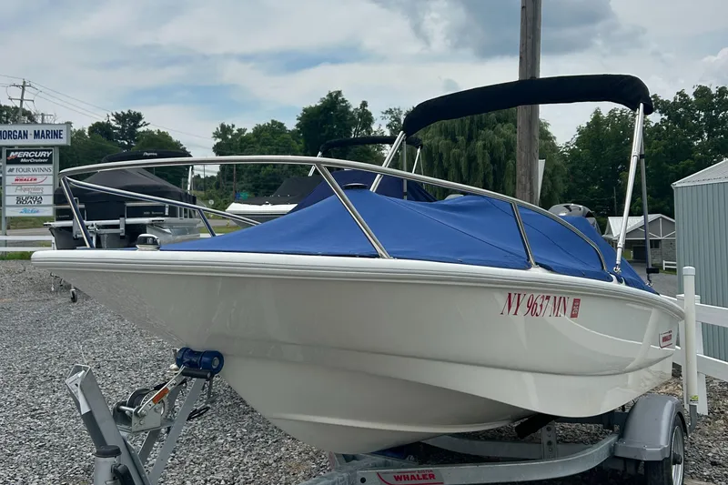 Slide: The Image of 2018 Boston Whaler 130 Super Sport boat with blue cover on trailer at Morgan Marine. - 3