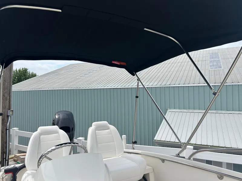 Slide: The Image of 2018 Boston Whaler 130 Super Sport boat with canopy and white seating. - 4